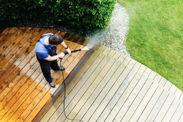 A detailed picture showing someone cleaning his compound using a pressure washer