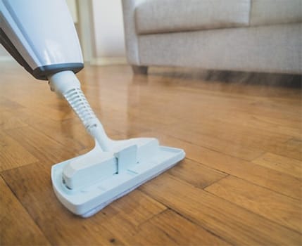 Cleaning the floor with a dry steam cleaner