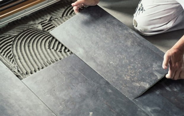 placing dark grey ceramic floor tiles