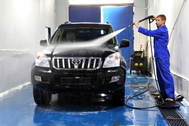 Always hold the pressure washer away from your body, as this man demonstrates