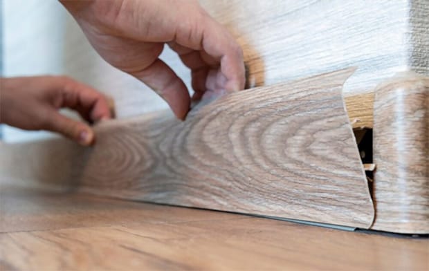 You have to remove the round-quarter trim before removing the vinyl flooring